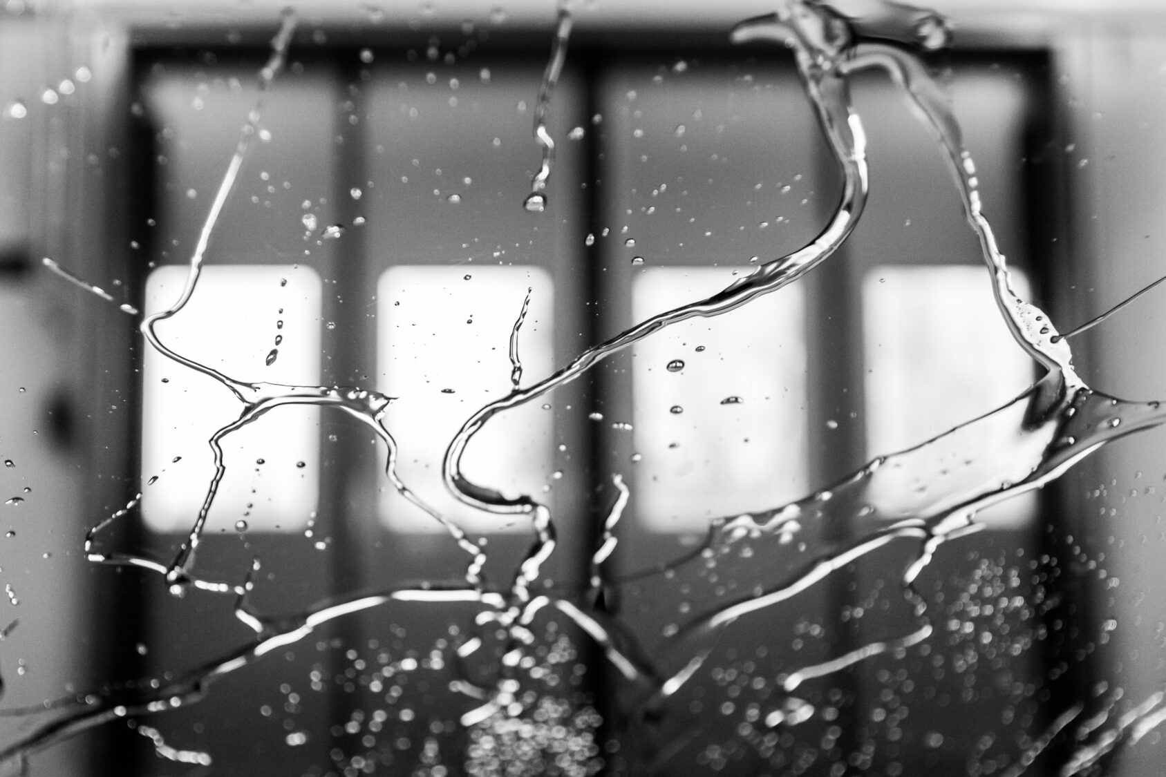 Autopesulan ovet märän lasin takaa katsottuna